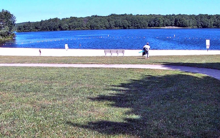 man on shore heading for lake