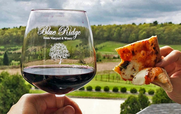 Blue Ridge Estate Winery glass of red wine and slice of pizza on deck