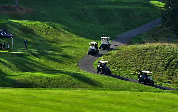 four golf carts going up the hill