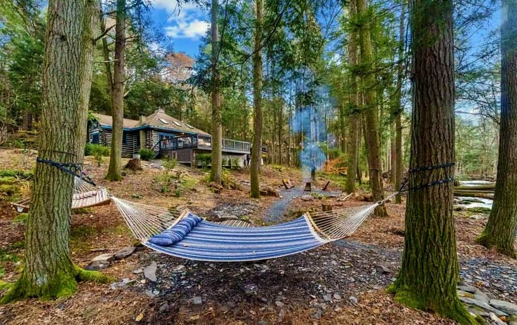 cozy creek cabin exterior and hammock by creek