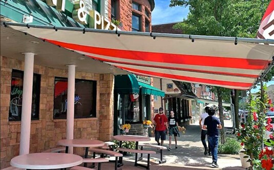 Elegante Restaurant sidewalk tables with awning over top