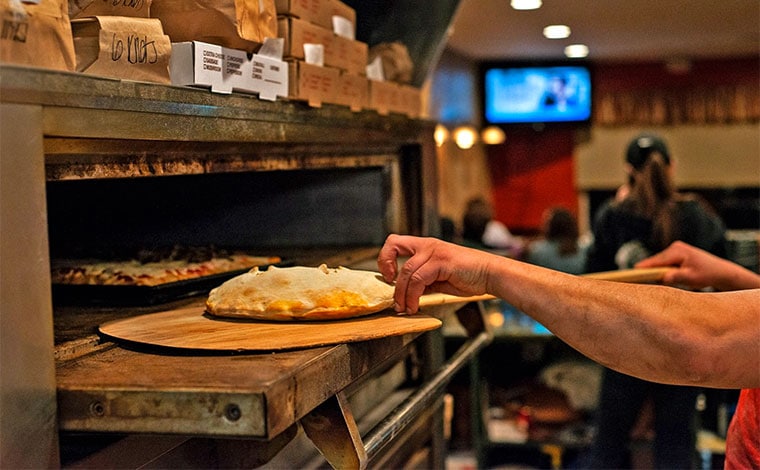 John's of Arthur Avenue making calzone in oven