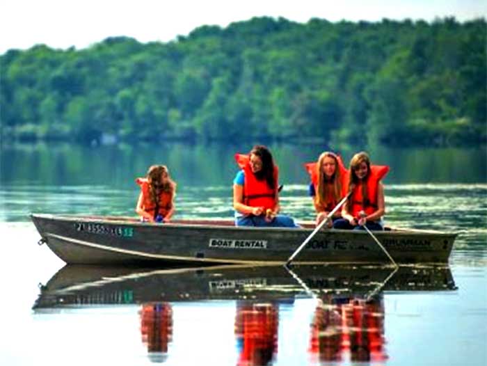 Promised Land Boat Rental girls on canoe on water” width=“700” height=“526” class=