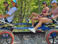 4 people on tandem bike on railroad tracks