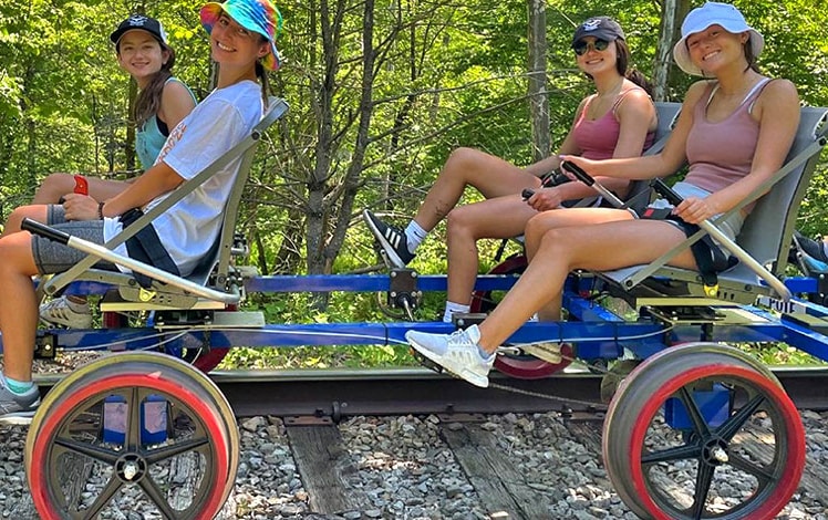 4 people on tandem bike on railroad tracks