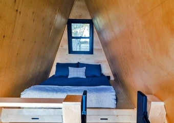 Tiny Black A-Frame bedroom on second level with ladder