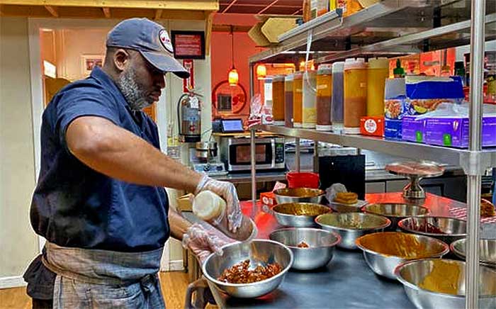 Owner Kurt Cummings sauces up some wings.