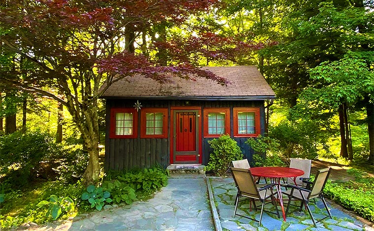 red and brown cottage with patio and table