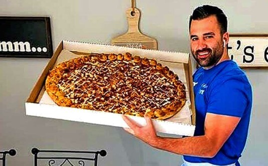 benny's pizzeria man holding pie