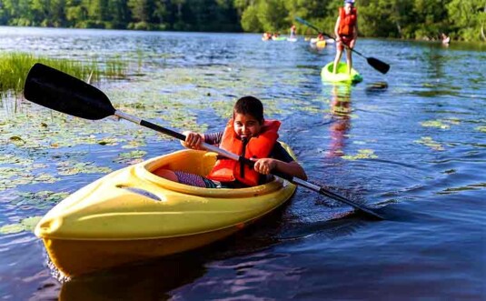 camp nesher kid in boat on lake