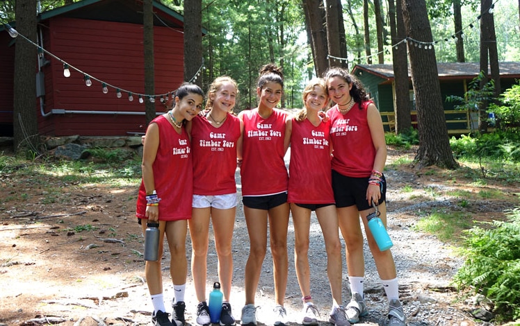camp-timber-tops-girls-friends-in-front-of-cabins