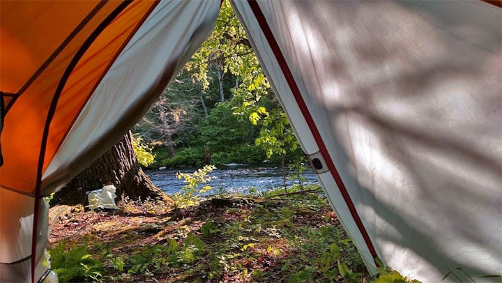 camping tent in the woods overlooking the stream