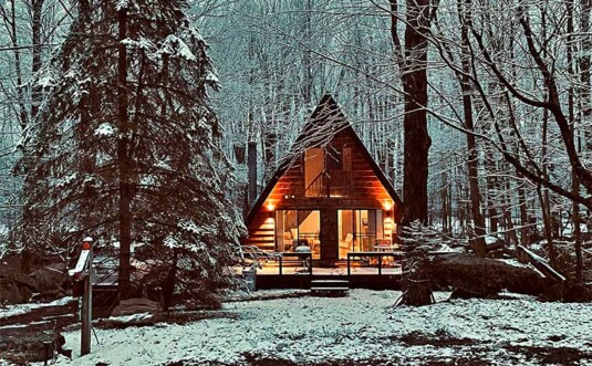 exterior a-frame cabin in the woods in winter snow