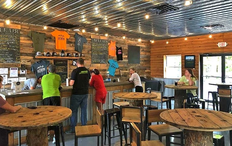 Log Tavern Brewing drinking room with tables and bar
