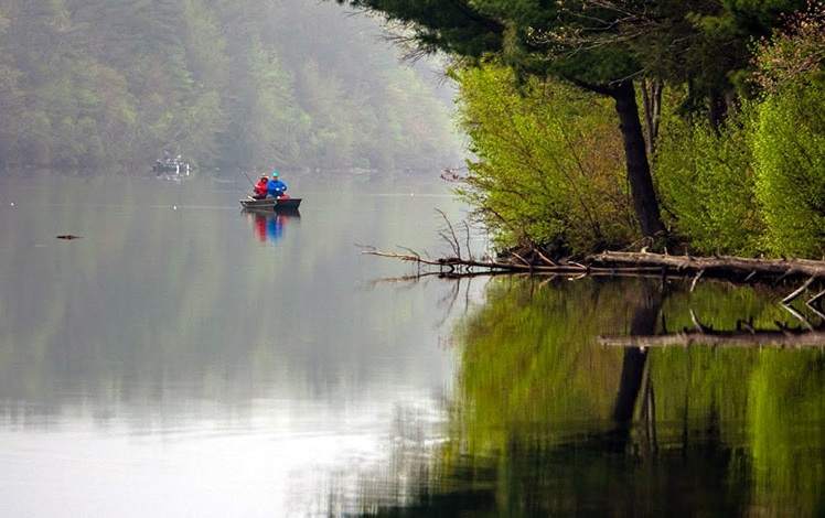 couple fishing on a foggy lake