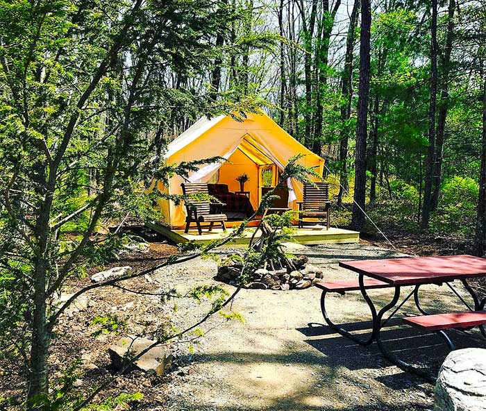 glamping tent site with picnic table and firepit