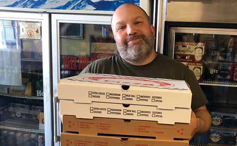 palumbos pizza owner holding pizza boxes
