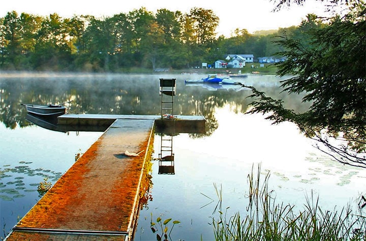 Perlman Camp dock, boat, and cottages on shore across lake