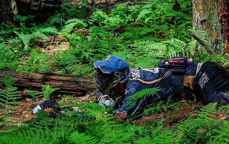 skirmish paintball player crouching in field