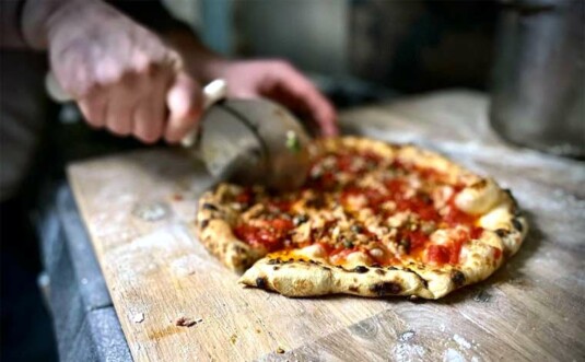 The Old Foundation chef cutting pizza